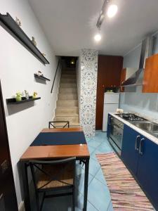 een kleine keuken met een tafel en een trap bij Atri Guest House in Napels