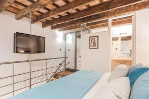 a bedroom with a bed and a tv on the wall at San Telmo Suites in Buenos Aires
