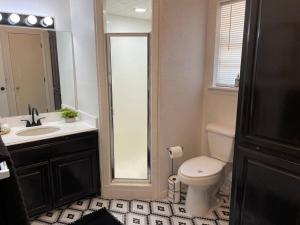 ein Badezimmer mit Toilette, Waschbecken und Spiegel in der Unterkunft Shiloh House 3-bed, 2 bath, living room, garage in Amarillo