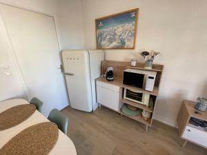 a small room with a refrigerator and a microwave at T2 pla d'adet au pied des pistes in Saint-Lary-Soulan
