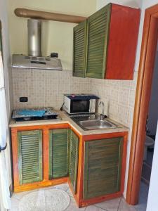 una pequeña cocina con fregadero y microondas en GIGIOTTO, en Siracusa
