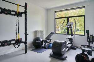 un gimnasio con máquinas de correr y una ventana en Moleneinde 10, en Weelde