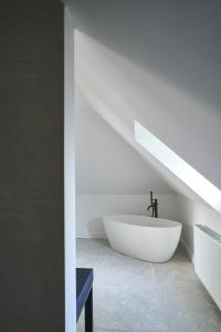 a bathroom with a white bath tub and a sink at Moleneinde 10 in Weelde