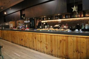 a bar with a person standing behind a counter with food at HOSTAL BURGALES in Milagro