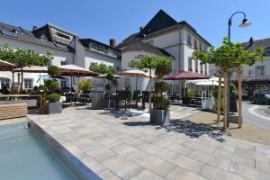 un hotel con un patio con mesas y sombrillas en Hotel Saarburger Hof, en Saarburg