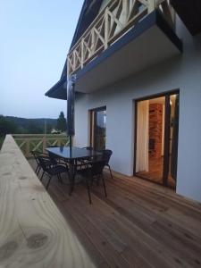 un patio con mesa y sillas en una terraza en Brzozowy Zagajnik Bieszczady - Domki z Balia Ogrodowa en Bereżnica Wyżna