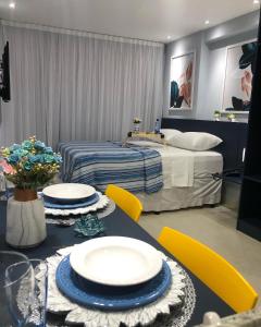 ジョアンペソアにあるApart hotel- FLAT no melhor do Manaíra 401のダイニングテーブルとベッドが備わる客室です。