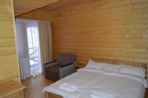 a bedroom with a white bed and a chair at Біла хата in Iltsi