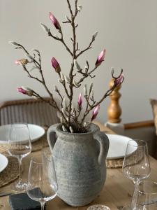 a vase with flowers in it on a table with wine glasses at The Bakehouse in Kelso