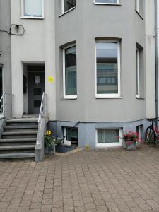a building with stairs and flowers in front of it at Vakantie Aan Zee in De Panne