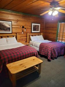 a bedroom with two beds and a ceiling at Shaver Lake Village Hotel in Shaver Lake