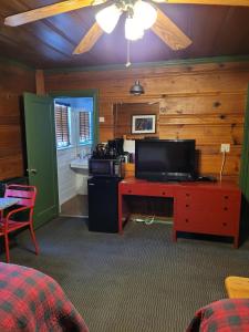 a room with a tv and a desk with a television at Shaver Lake Village Hotel in Shaver Lake