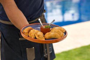 a person holding a plate of fried food at Patios de Cafayate - Wine Hotel & Restaurant in Cafayate +59 photos
