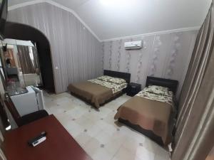 a hotel room with two beds and a television at Hotel Selika in Rustavi