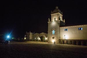 un edificio con una torre de reloj por la noche en Patios De Cafayate en Cafayate
