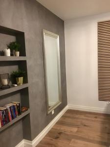 a room with a mirror on a gray wall at kameralny apartament II in Olsztyn