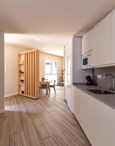 a kitchen with white cabinets and a wooden floor at A TU VERA VUT-09/298 in Burgos