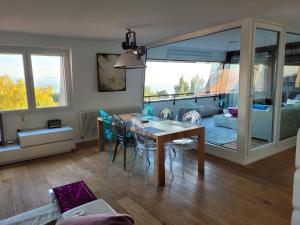 3-bedroom apartment with spectacular view في نوشاتيل: غرفة طعام وغرفة معيشة مع طاولة وكراسي