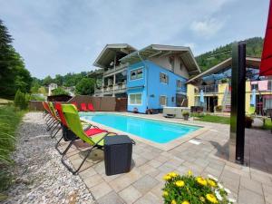 a swimming pool with chairs and a house at Ferienparadies Alpenglühn in Berchtesgaden