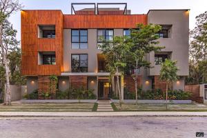 a house with a wooden facade with trees in front of it at Chic Suites in the Heart of Tulum by Stella Rentals in Tulum