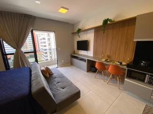 a bedroom with a bed and a couch and a kitchen at Edf Time - conforto e sofisticação in Maceió
