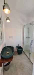 a bathroom with a green sink and a shower at Lettu di Ita - Spectacular Gallura Stazzu with sea view and pool in Santa Teresa Gallura