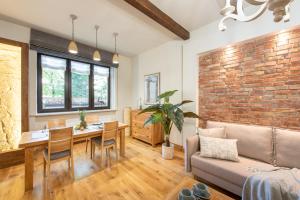 a living room with a table and a brick wall at Krakowhomes in Kraków