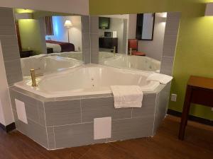 a large bath tub in a bathroom with at Skylight Inn Willoughby - Cleveland Mentor in Willoughby +25 photos
