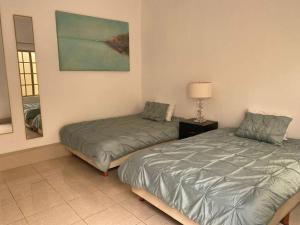 a bedroom with two beds and a lamp in it at Hotel Ol&eacute; in Monterrey