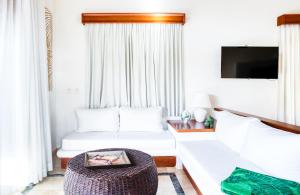 ein Wohnzimmer mit einem weißen Sofa und einem Tisch in der Unterkunft Ileverde 21 - Private garden Bungalow in Punta Cana