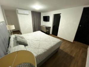 - une chambre avec un lit, une table et une télévision dans l'établissement Hotel Olé, à Monterrey