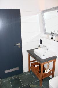 a bathroom with a sink and a black door at Harzbutze 60 in Sankt Andreasberg