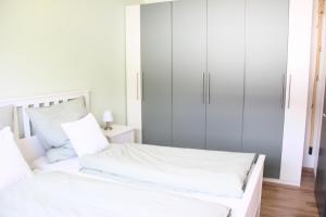 a white bedroom with white cabinets and a bed at Harzbutze 60 in Sankt Andreasberg