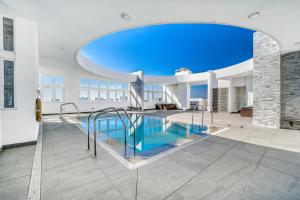 ein Schwimmbad in einem Gebäude mit einem großen Fenster in der Unterkunft Sunny Side 3BR W/ View, Parking, Pool & Gym in Viña del Mar