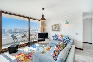 ein Wohnzimmer mit einer Couch und einem Glastisch in der Unterkunft Sunny Side 3BR W/ View, Parking, Pool & Gym in Viña del Mar