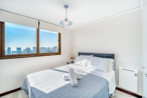 ein Schlafzimmer mit einem großen Bett mit Fenster in der Unterkunft Sunny Side 3BR W/ View, Parking, Pool & Gym in Viña del Mar + 16 Fotos