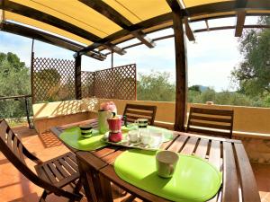 a wooden table with a green plate on it on a patio at Recidence Villa Olivia in Itri
