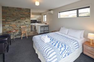 a bedroom with a large bed and a kitchen at Little Rock in Lake Tekapo