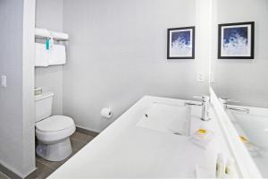ein weißes Bad mit einem WC und einem Waschbecken in der Unterkunft Holiday Inn Hotel & Suites - Calgary Airport North, an IHG Hotel in Calgary