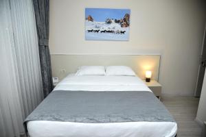 A bed or beds in a room at Trigo Hotel