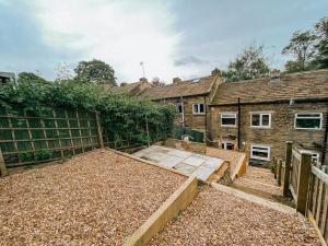 a backyard of a house with a building at LITTLE RED HOLIDAY HOME - 2 Bed House with Free Parking within West Yorkshire, local access to the Peak District in Halifax