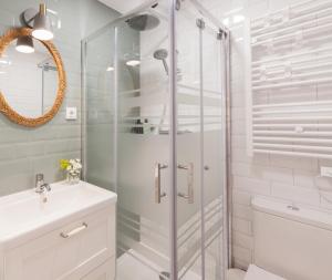 biała łazienka z prysznicem i umywalką w obiekcie Madrid Comfort Suites w Madrycie