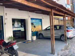 une voiture garée devant un immeuble avec une peinture dans l'établissement Pousada Nascer do Sol, à João Pessoa