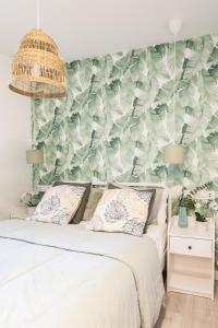 um quarto com uma cama com papel de parede verde e branco em Dolphin Rentals Hortaleza em Madrid