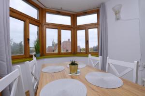 jadalnia ze stołem, krzesłami i oknami w obiekcie Piękny Apartament 3city z Balkonem w Centrum Sopotu by Noclegi Renters w mieście Sopot