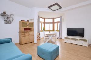 salon z niebieską kanapą i telewizorem w obiekcie Piękny Apartament 3city z Balkonem w Centrum Sopotu by Noclegi Renters w mieście Sopot