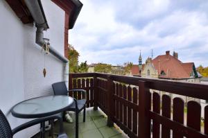 balkon ze stołem i krzesłami oraz budynek w obiekcie Piękny Apartament 3city z Balkonem w Centrum Sopotu by Noclegi Renters w mieście Sopot