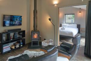 a living room with a bedroom with a fireplace and a bed at Designer Cabin - Lake Tekapo in Lake Tekapo