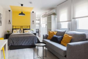 uma sala de estar com uma cama e um sofá em Dolphin Rentals Hortaleza em Madri