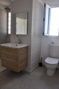 a bathroom with a sink and a toilet at Villa Salem Maison d'architecte toute équipée & piscine in Arkou